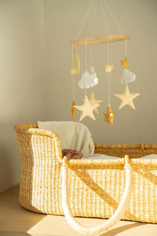 Baby in a crib with a star-shaped mobile hanging above