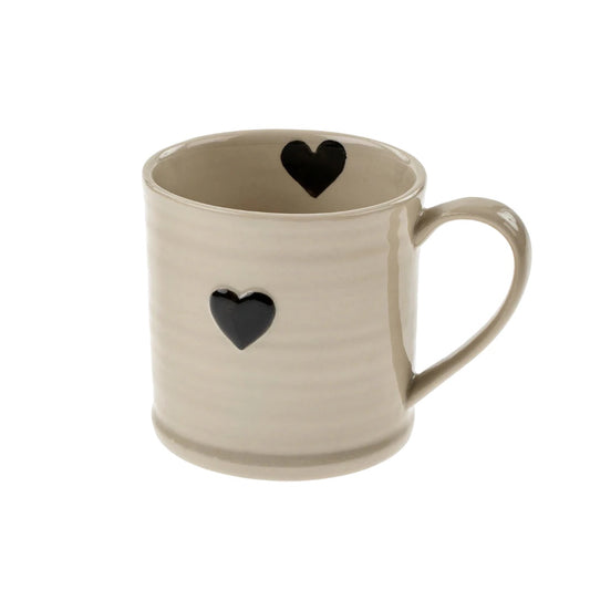 Beige mug with black heart designs on a white background