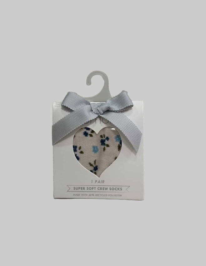 Pack of socks with a heart-shaped cutout and floral design on a textured surface