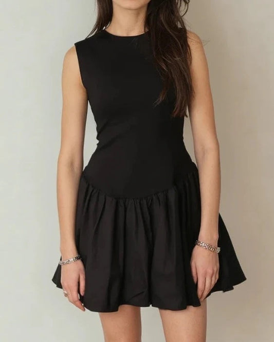 Black sleeveless dress worn by a person on a plain background