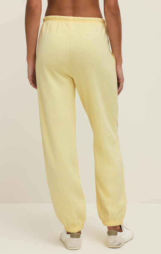 Yellow sweatpants worn by a person on a plain background