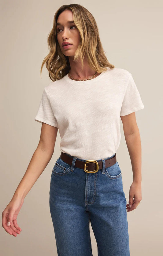 Woman wearing a white t-shirt and blue jeans against a beige background | Z Supply Foundation Slub Tee | White