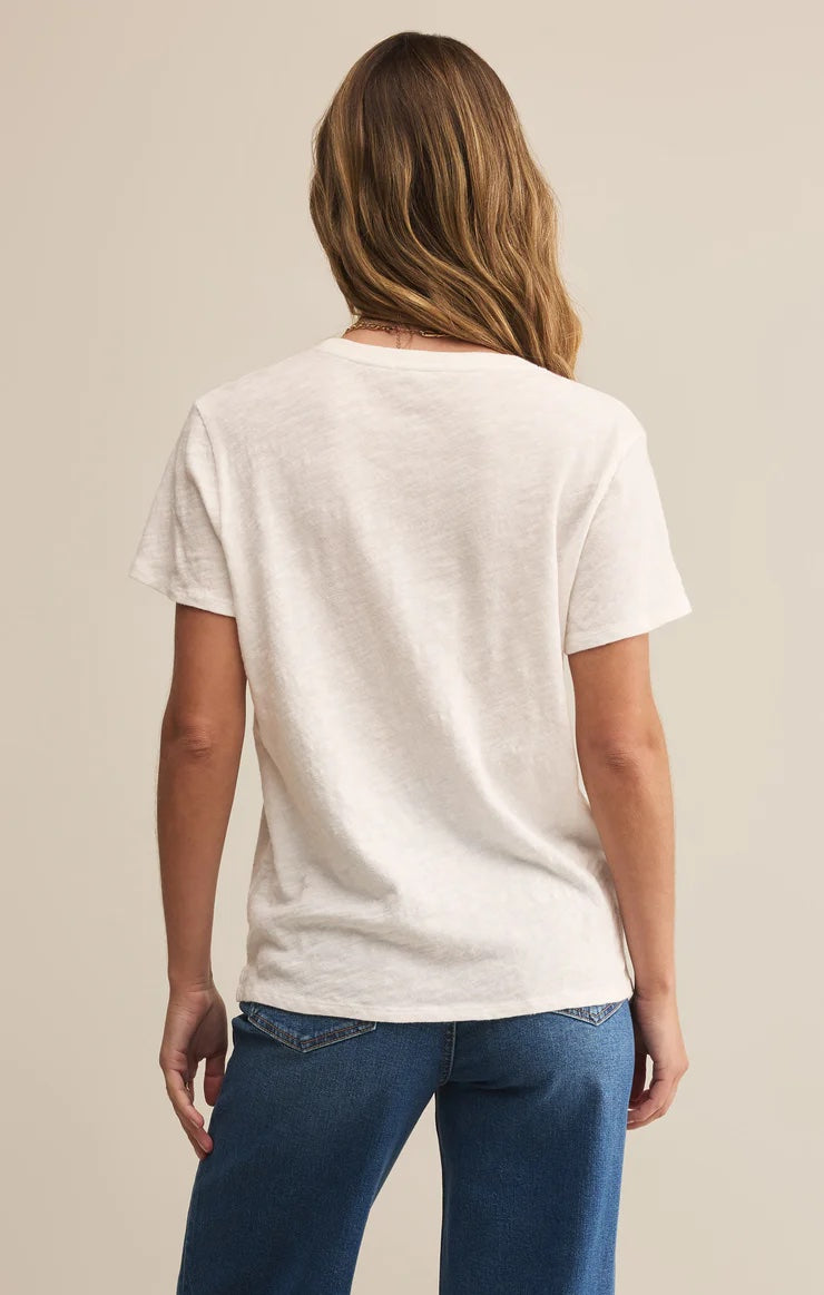 Woman wearing a white t-shirt and blue jeans against a beige background | Z Supply Foundation Slub Tee | White