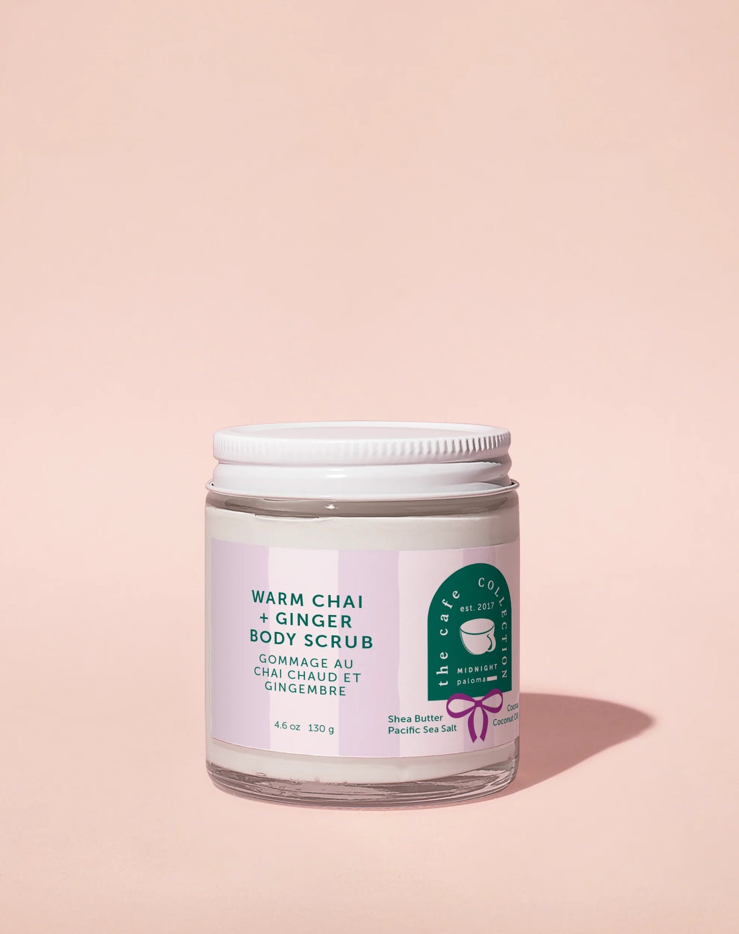 Jar of warm chai and ginger body scrub on a pink background