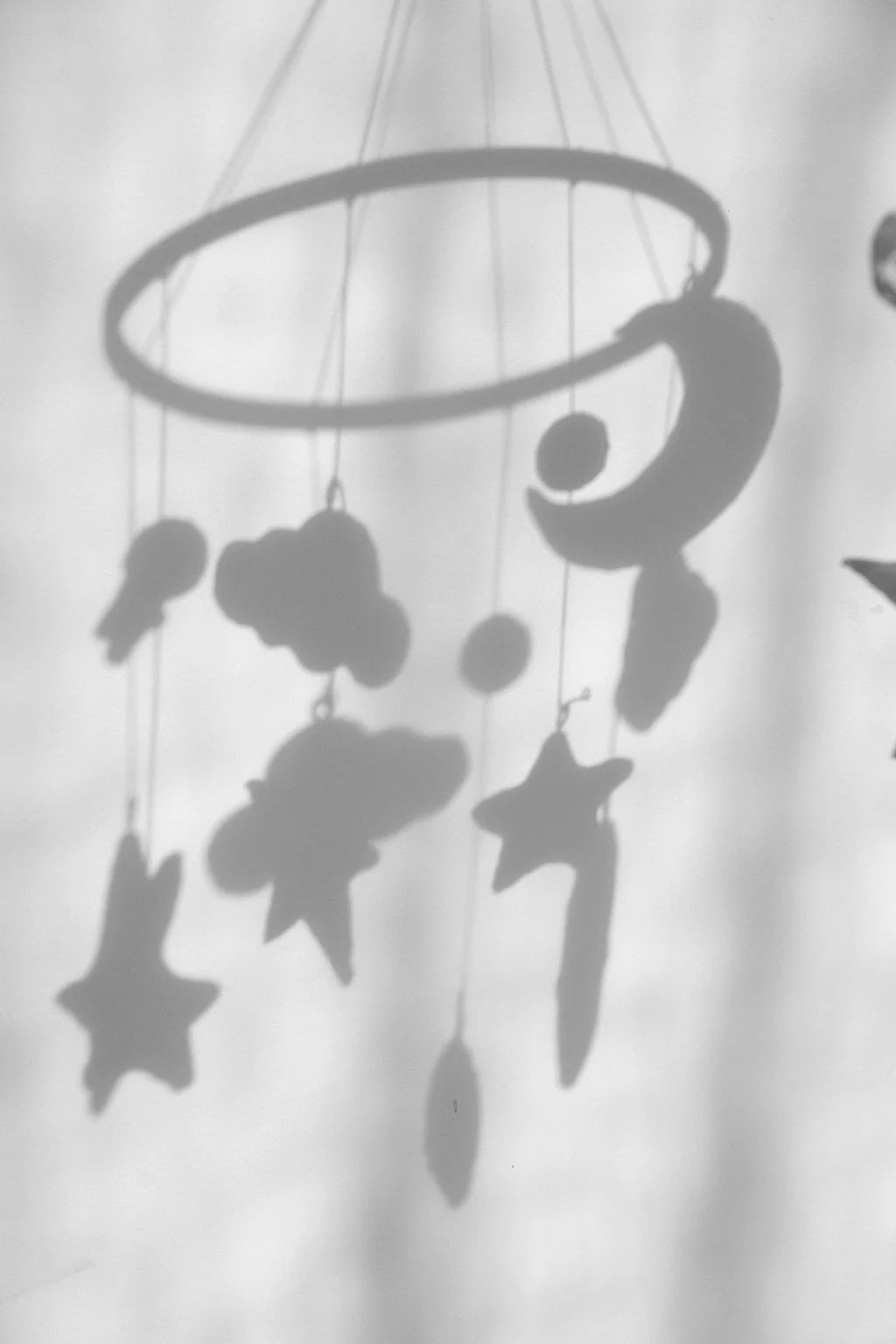 Black star-shaped mobile hanging against a white background