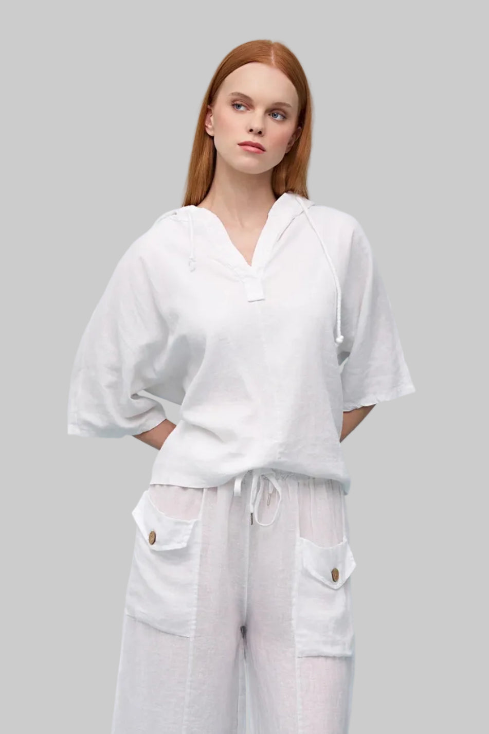 Woman wearing a white outfit on a light blue background