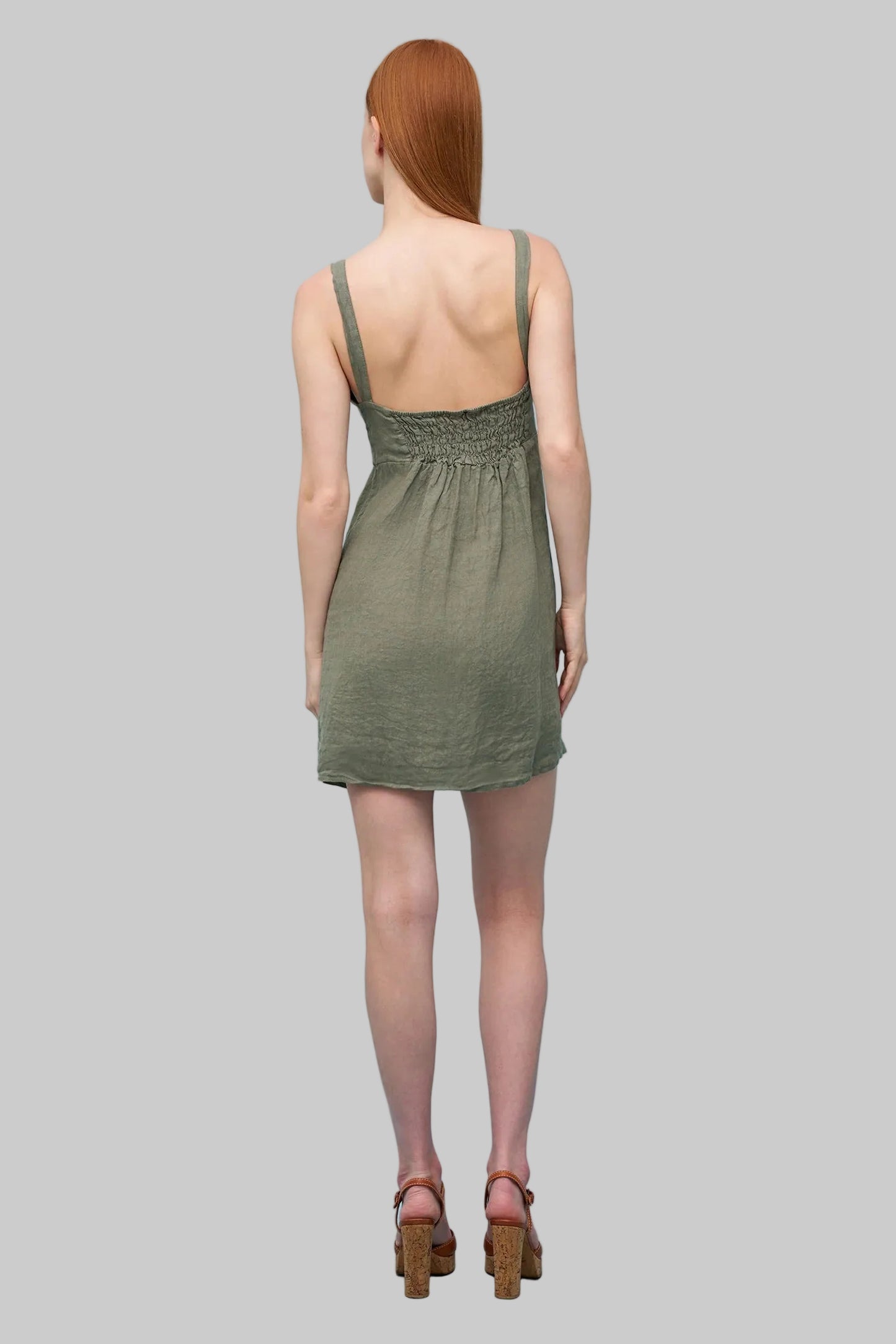 Woman wearing a green dress against a light grey background