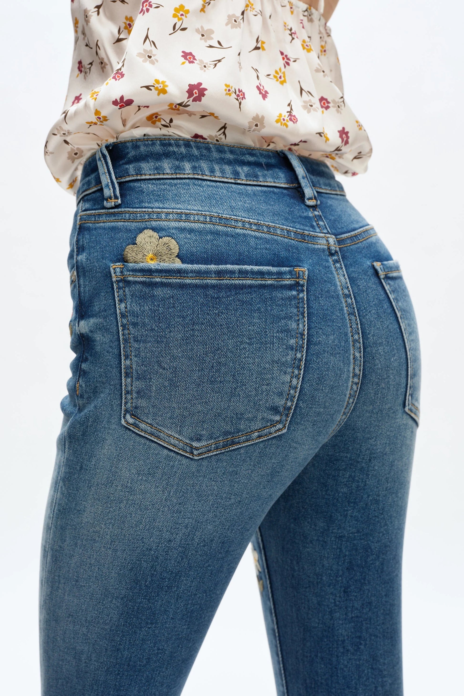 Blue jeans with floral design on a white background