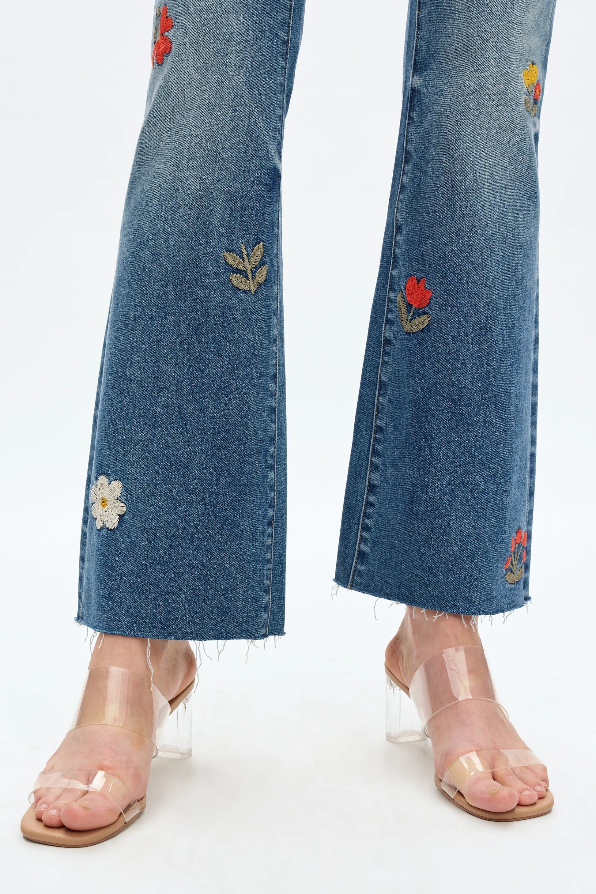Blue jeans with floral embroidery on a white background