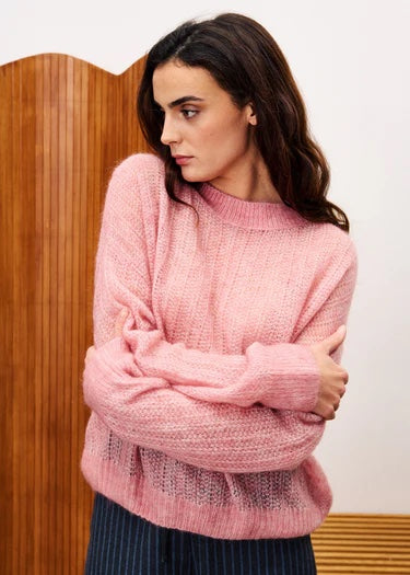 Woman wearing a pink sweater with a wooden panel background | FRNCH Lys Sweater | Pale Pink, Designed in France