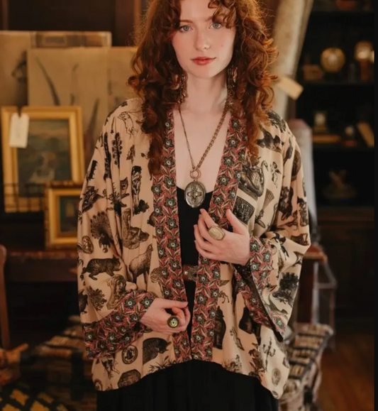 Woman wearing a patterned kimono-style garment in a vintage store setting