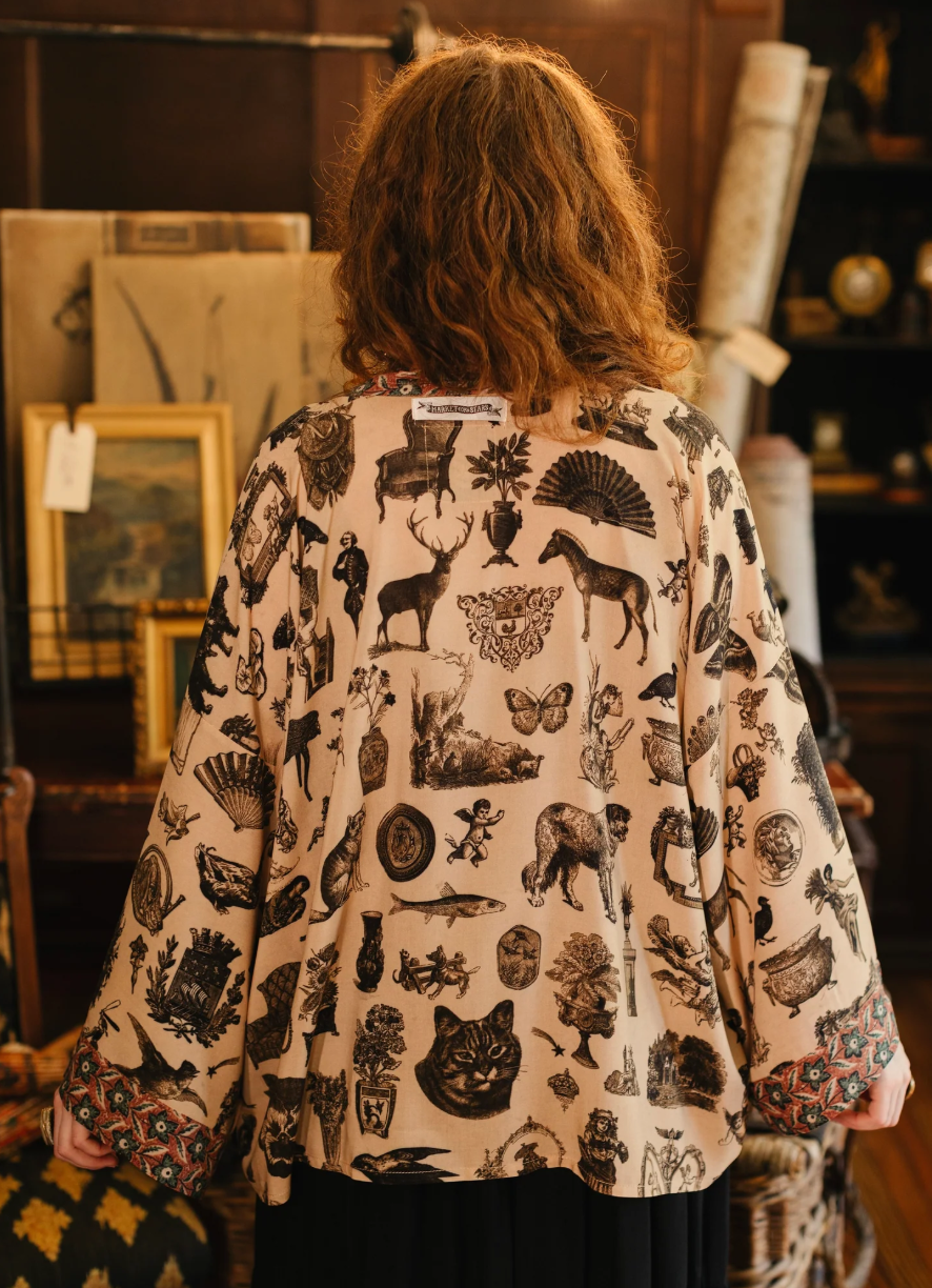 Person wearing a patterned blouse in an indoor setting with decor elements.