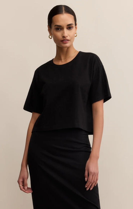 Woman wearing a black outfit against a beige background | Z Supply On The Go Tee | Black