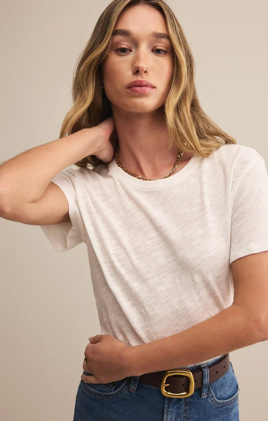 Woman wearing a white t-shirt and blue jeans against a beige background | Z Supply Foundation Slub Tee | White