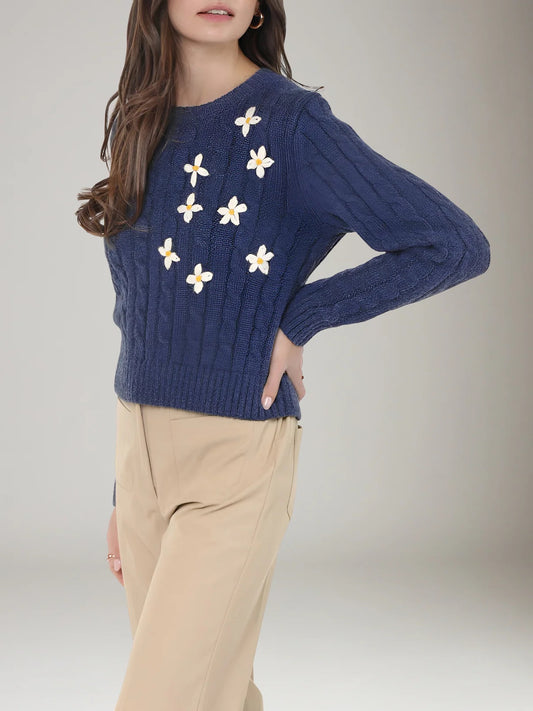 Woman wearing a blue sweater with floral patterns on a plain background | Sadie and Sage | Lulu Embroidered Daisy Sweater, Navy