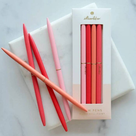 Set of red and pink pens with a branded box on a marble surface | Idlewild Slim Pen | Spectrum Poppies